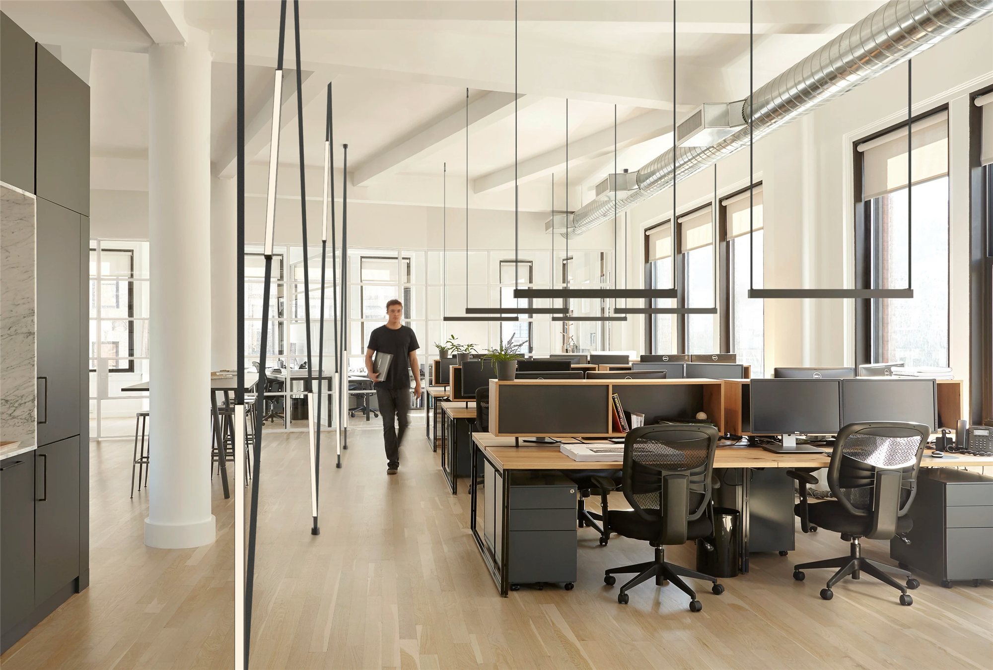 Open plan office with black linear pendants and vertical luminous battens